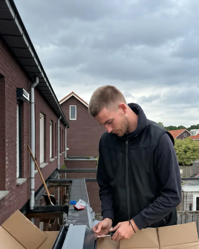 Bas werkt aan een rolluikgeleider met gereedschap